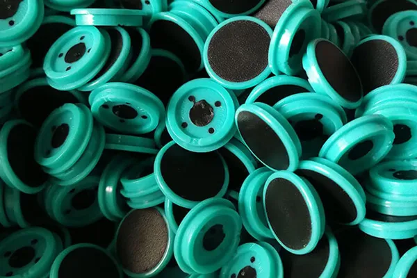 Mass-produced teal plastic pulleys from injection molding
