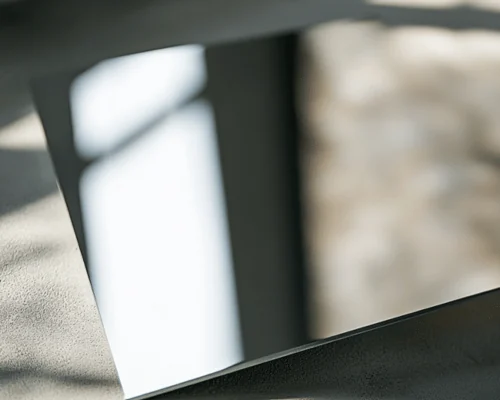 Mirror-polished aluminum sheet reflecting a window
